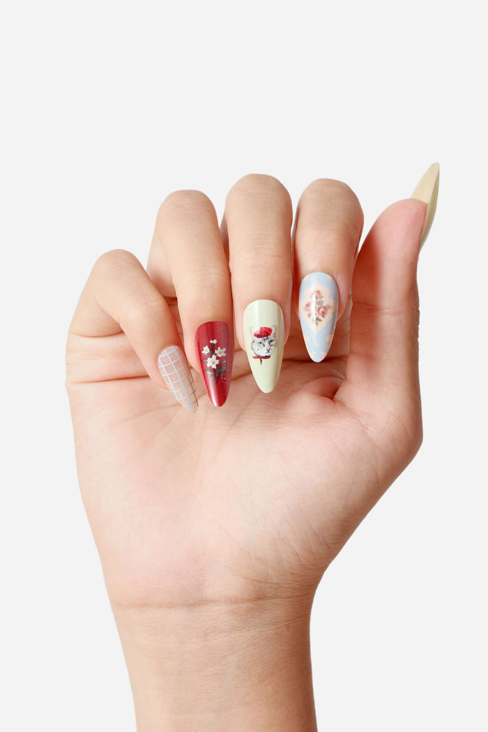 Almond press-on nails with cat collage, floral, and checkered designs in various colors.