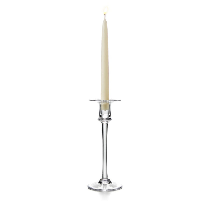 Tall clear glass candlestick with a cream taper candle and metal bobeche, tapered stem, and circular base.