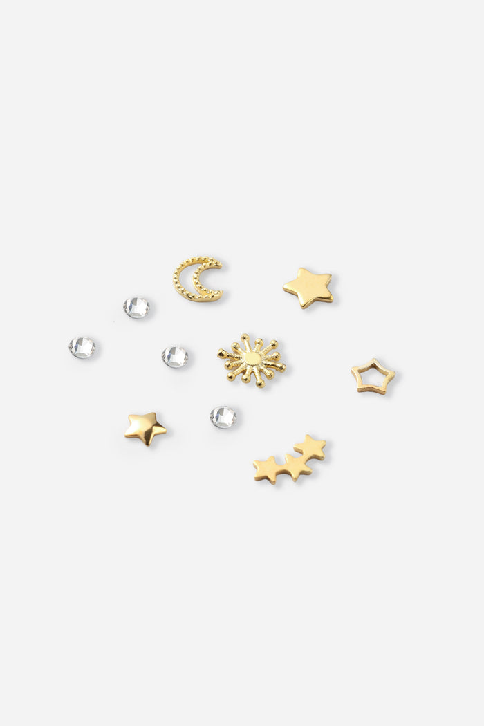 Gold celestial tooth gems including a crescent moon, stars, and sunburst, with clear rhinestones.