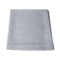 Four light gray linen napkins stacked and folded.