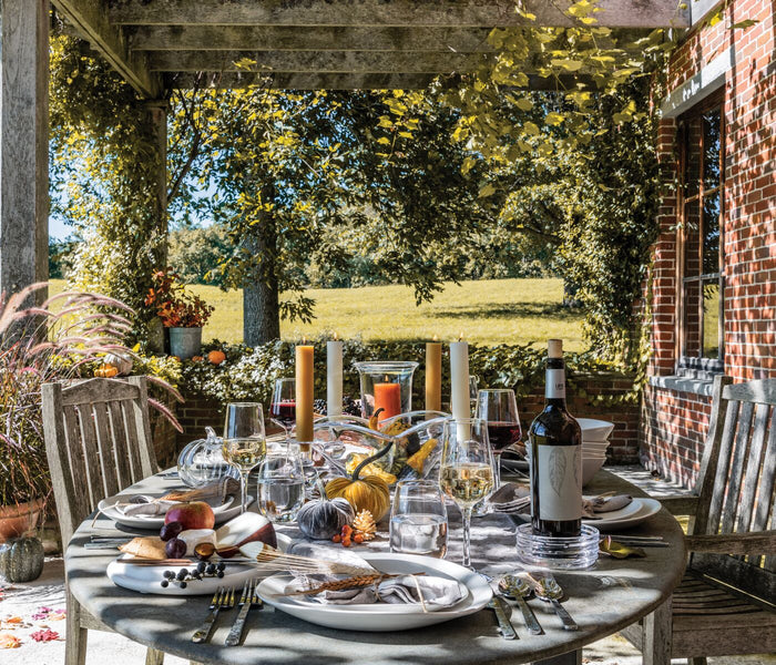 Five-piece flatware setting displayed on an outdoor dining table with place settings including forks, knives, and spoons.