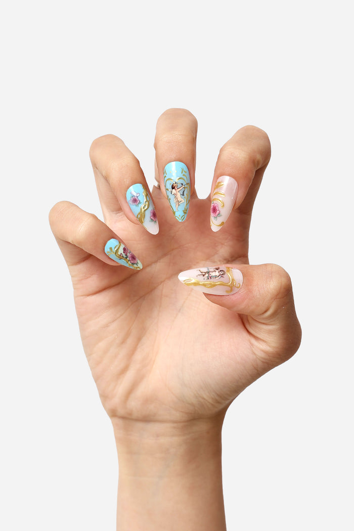 Cherub Rococo almond press-on nails featuring cherub and floral designs with gold accents.