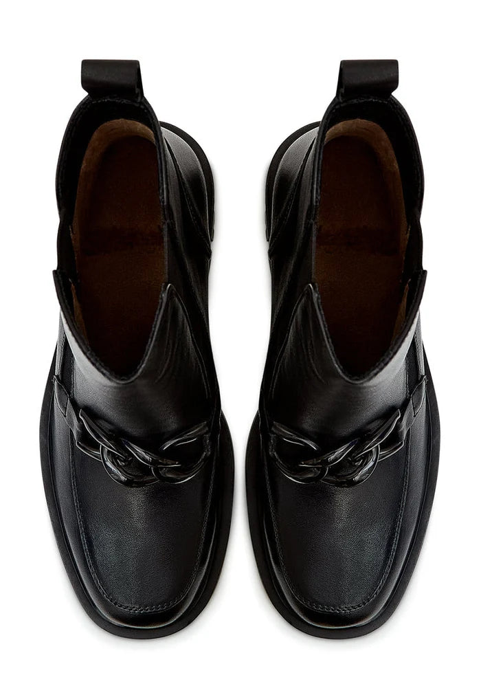 A close-up image of trendy black ankle boots with chunky heels and stylish chain details, perfect for a fashionable look.