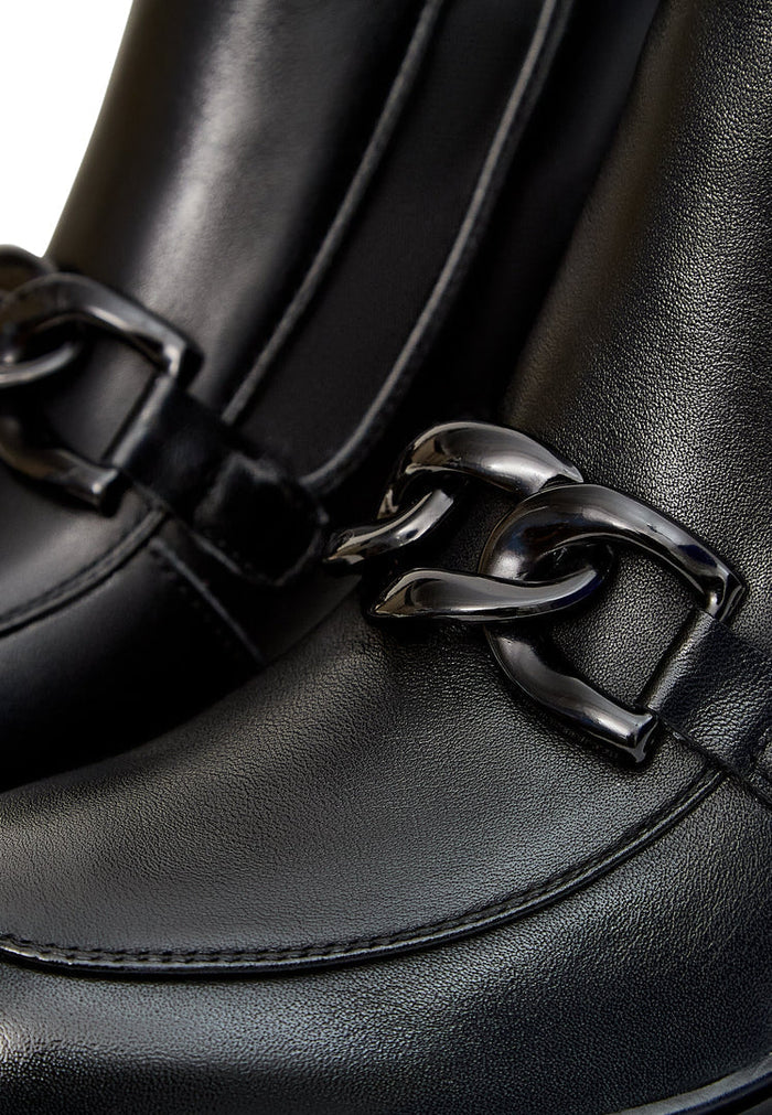 A pair of stylish black ankle boots with chunky heels and edgy chain details, perfect for a trendy and fashionable look.