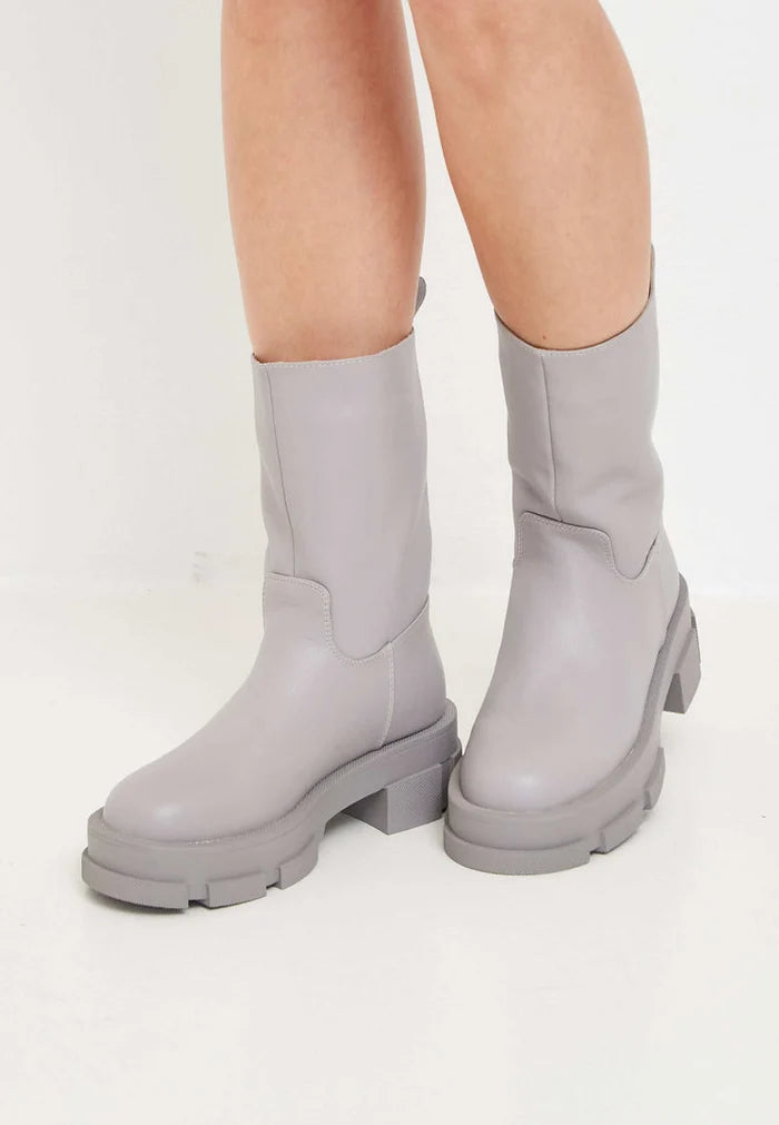 A stylish pair of women's fashion ankle boots in beige leather, featuring chunky soles for a trendy look.