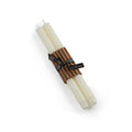 Two cream-colored taper candles bundled together with a brown corrugated paper and black ribbon band.