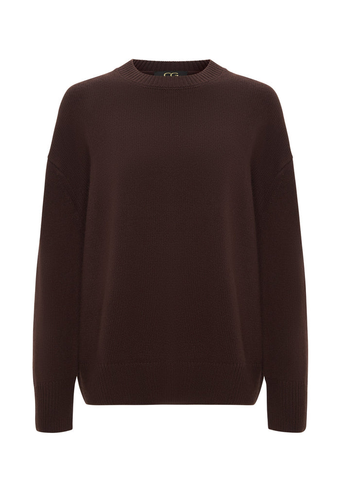 A woman wearing a classic crew neck Mulan Brown sweater - perfect for the winter season and casual knitwear fashion.