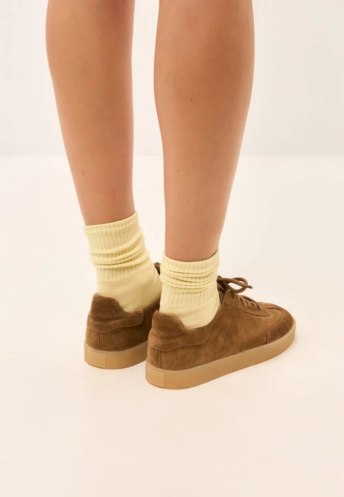 A stylish pair of retro inspired brown suede sneakers with a classic low-top design.