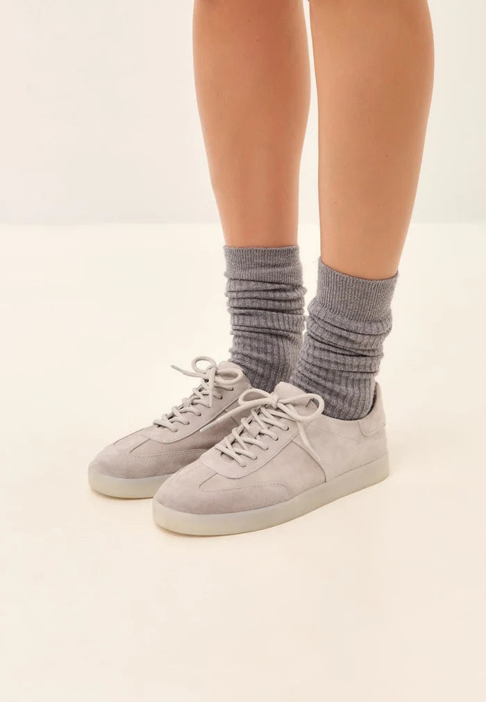 A close-up image of stylish gray suede low-top sneakers, a classic choice of footwear for any casual outfit.