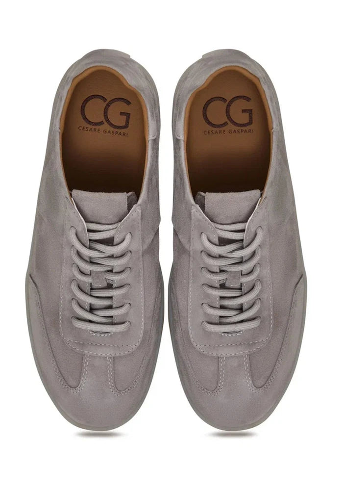 A stylish pair of classic low-top gray suede sneakers, the perfect choice for fashionable footwear enthusiasts.