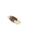 Two cream-colored tapered candles with brown wicks bundled together with a black label band.