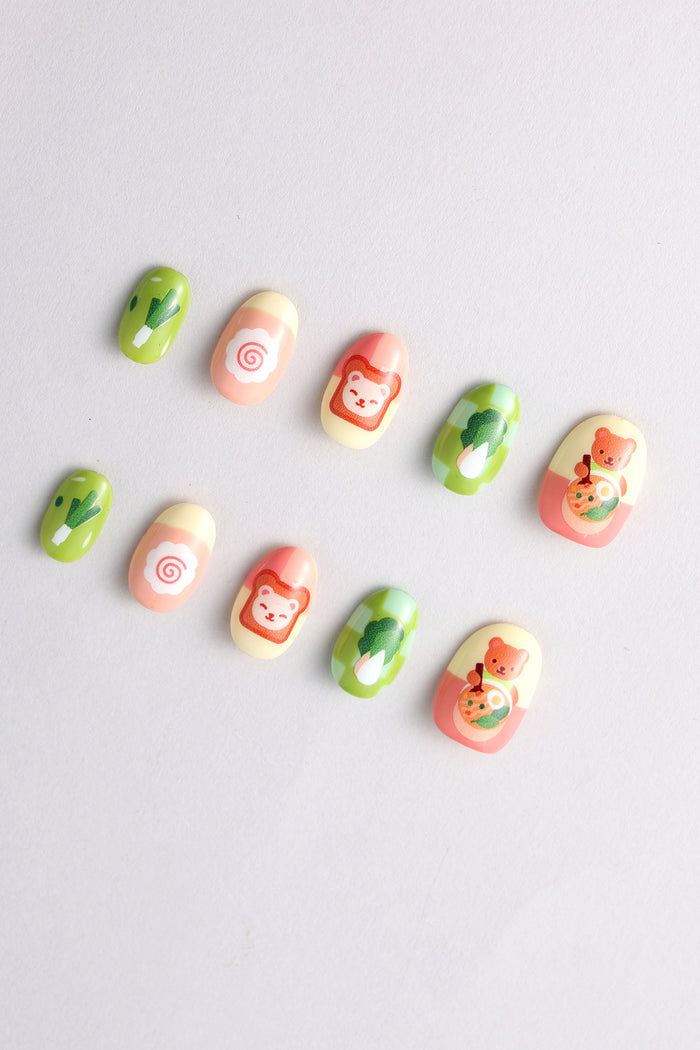 Cute press-on nails with cooking bear, food, and vegetable designs.