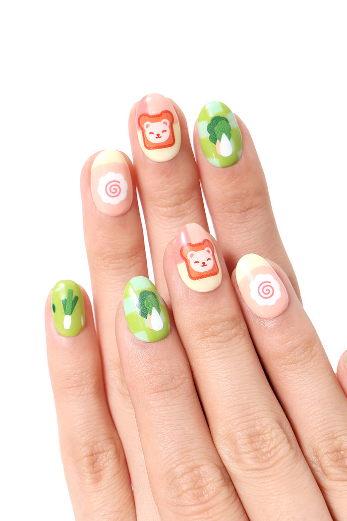Cooking bear press-on nails with kawaii food designs: toast, bok choy, and naruto swirls.