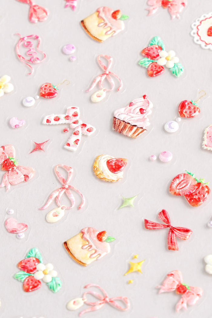 Sheet of Coquette Cutie nail stickers featuring pink bows, strawberries, cupcakes, and flowers.