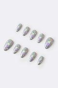 Cosmic Dance press-on nails: holographic silver with green alien on purple skirt, stars.