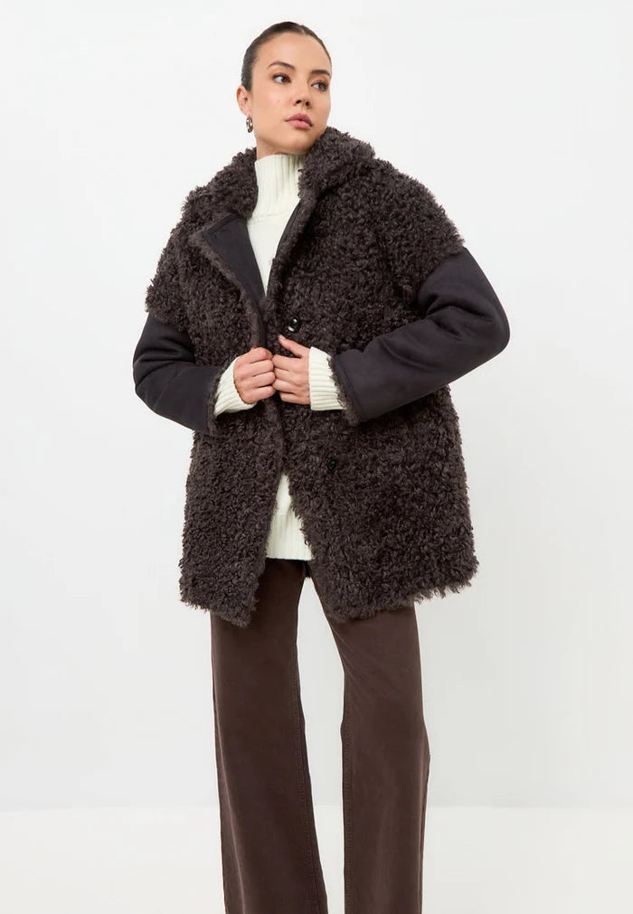 Stay warm and stylish this winter with the Eva shearling coat in brown. This black cozy coat is perfect for cold weather fashion.