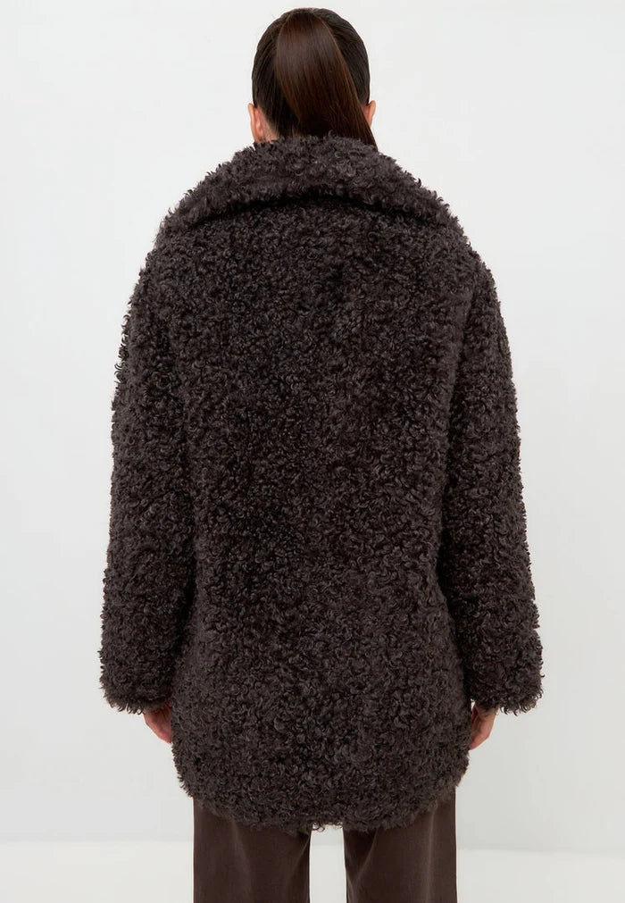 A stylish and cozy black shearling Eva coat, perfect for staying warm and fashionable in the cold weather.