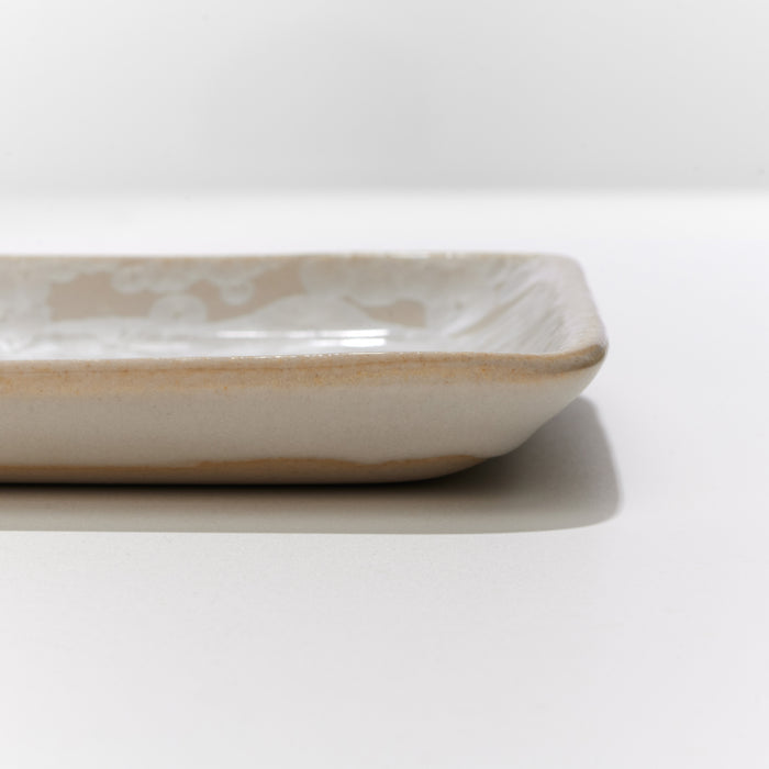 Small rectangular platter with cream-colored crystalline glaze and gently curved edges.