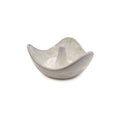 White ceramic ring holder with wavy bowl shape and central post for storing rings.