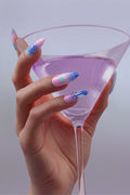 Woman's hand with Cyber Punk press-on nails holding a pink cocktail.