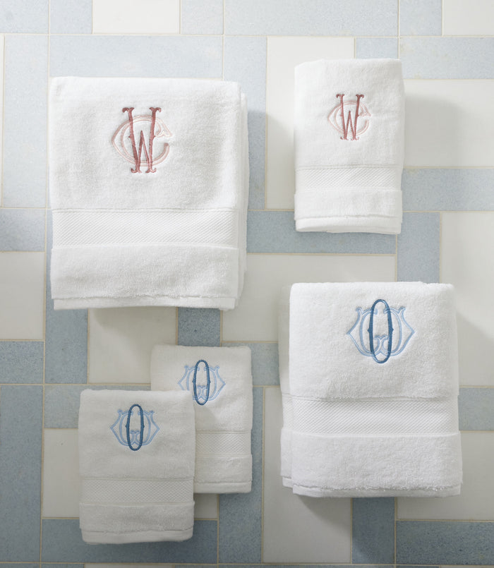Set of White Diamond Towels with embroidered monograms on a light blue and white tiled background.