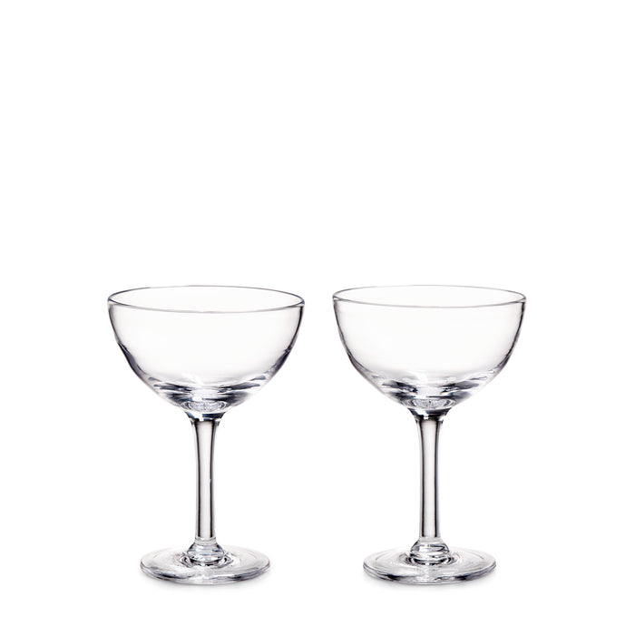 Two clear glass coupe glasses with stems and wide bowls on white background.