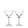 Two clear glass martini glasses with conical bowls and long stems on white background.