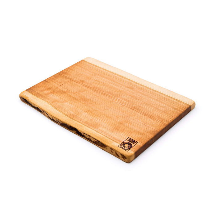 Cherry wood cutting board with natural live edges on two sides and brand logo on corner.