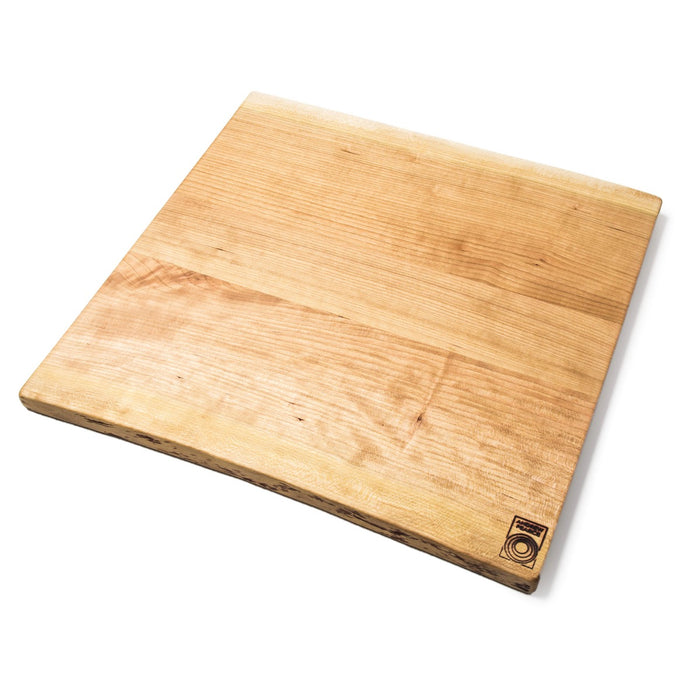 Cherry wood cutting board with natural grain and live edges, rectangular shape with rounded corners and brand logo on bottom