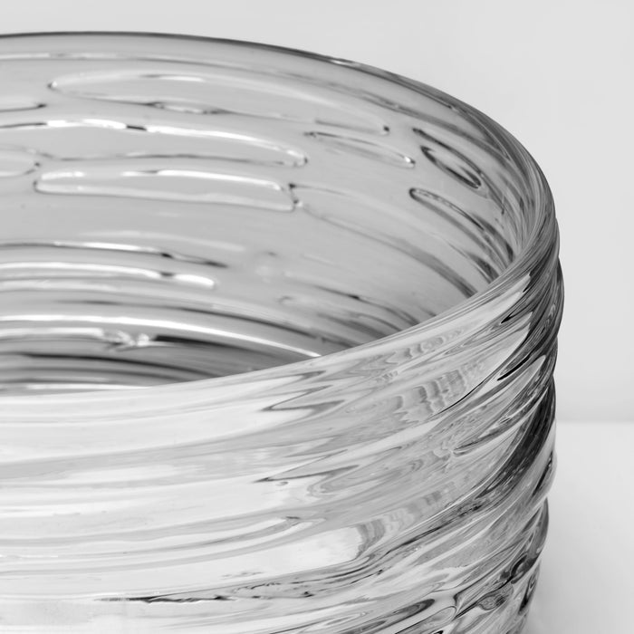 Clear glass coaster with concentric ridged pattern and swirled gray streaks throughout.