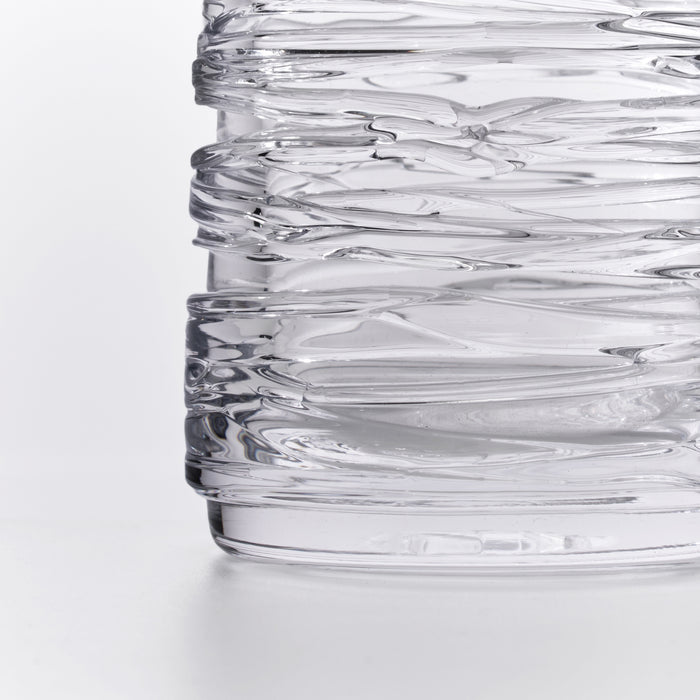 Clear glass carafe with horizontal wave-like texture pattern throughout the cylindrical body.