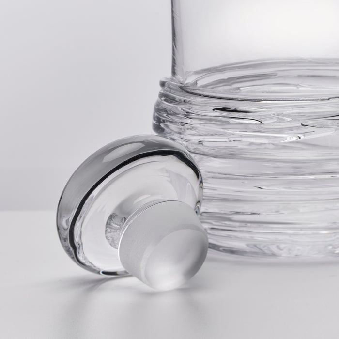 Clear glass decanter with horizontal ribbed texture and frosted stopper.