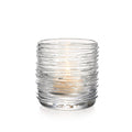 Clear glass tealight holder with horizontal textured ridges and a lit flame visible inside.