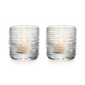 Two clear glass tealight holders with textured horizontal ridges and lit candles inside.