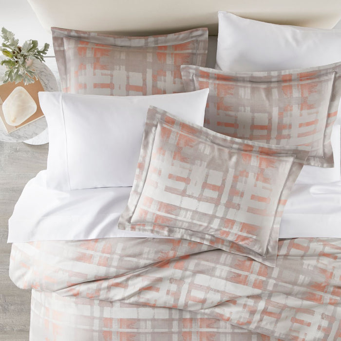 lifestyle image of Enzo shams and duvet in coral with white sheeting
