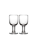 Two clear glass wine goblets with pedestal bases and rounded bowls.