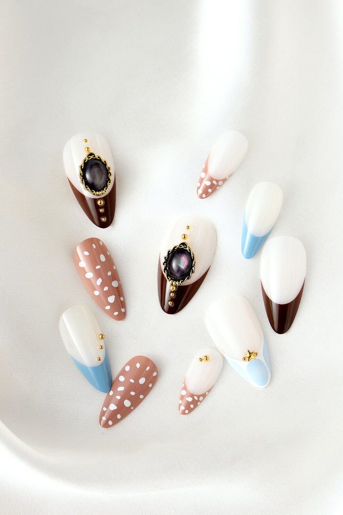 Fawning Over You almond press-on nails with white, brown, blue, and tan designs with gold accents.