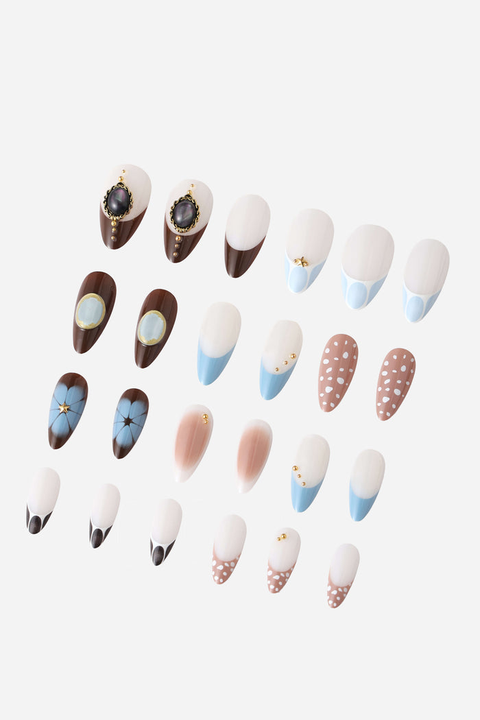 A variety of almond-shaped press-on nails with diverse designs, including floral, polka dots, and jeweled accents.