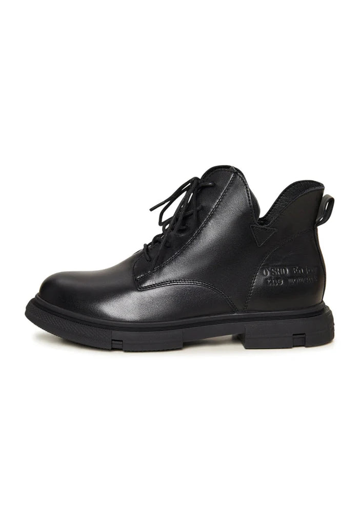 A pair of stylish black leather women's flat sole ankle boots with a chic design, perfect for everyday wear.