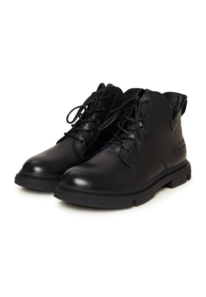 A stylish pair of black leather flat-sole ankle boots for women, featuring a sleek design with a flat heel.