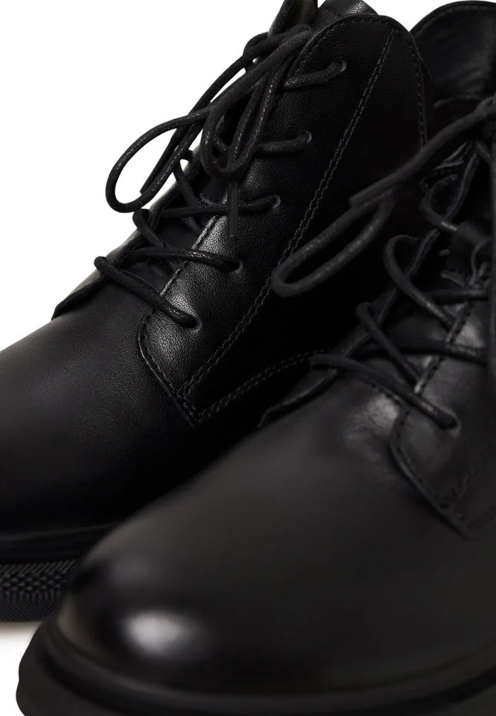 A stylish pair of black leather women's ankle boots with a flat sole and heel.