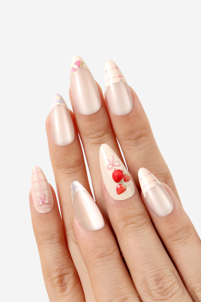 Floral Femme almond press-on nails with strawberry and bow designs.