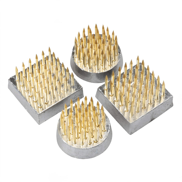 Four mini kenzans with brass pins in metal bases, two square and two round shapes.
