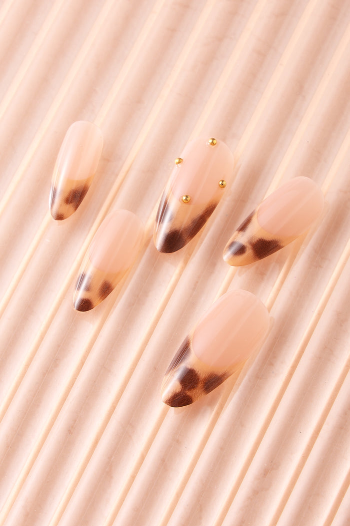 French tip press-on nails with a leopard print design and gold accents