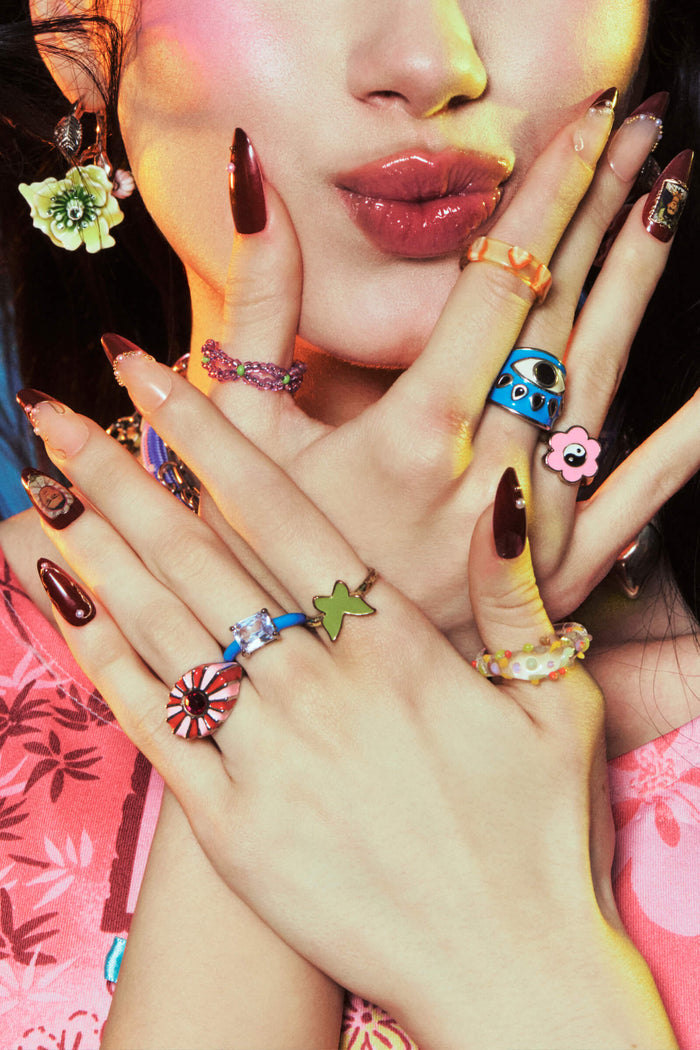 Frida Kahlo almond press-on nails with pearl accents and bold dark red tips.