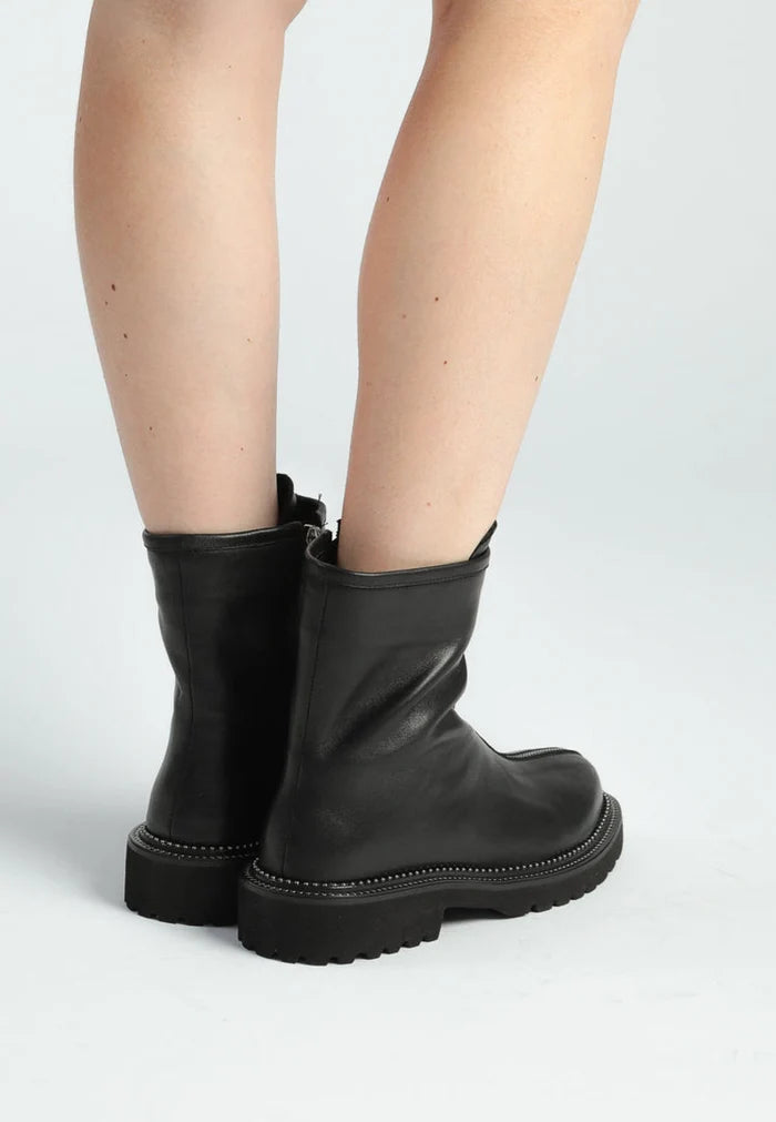 A stylish pair of women's front-zip ankle boots in black, featuring a trendy zipper design.