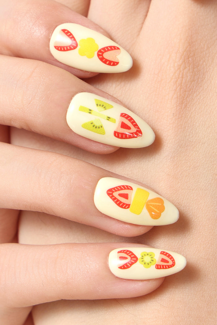 Press-on nails with a fruit sando design featuring strawberries, kiwi slices, and yellow accents.