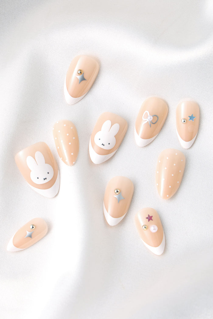 Almond press-on nails with Miffy, polka dots, bows, stars, and gems