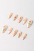 Garden Melody by Elaine Lee press-on nails with floral designs and pale peach and pink colors.