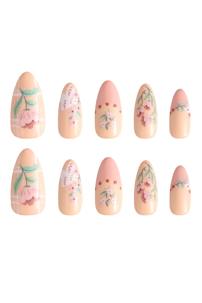 Garden Melody press-on nails with floral and bird designs on pale peach and pink base.